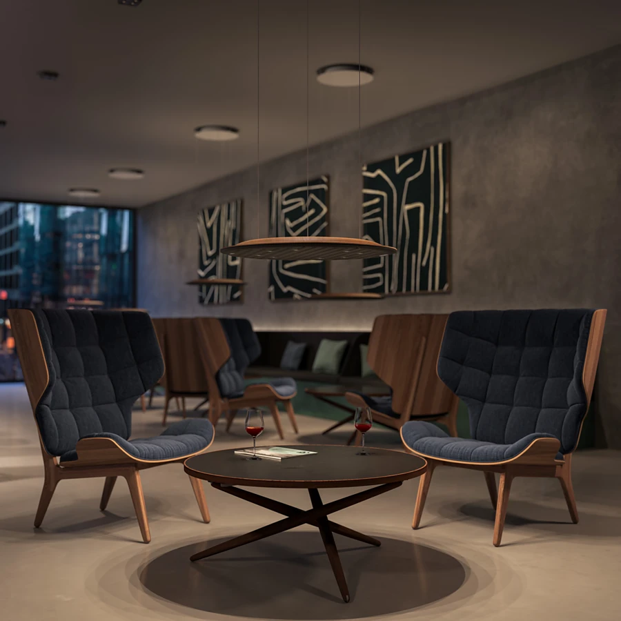 Discreet, atmospheric light is emitted from the Lighting Pad Lounge. With its upper part made of exclusive moulded wood and the lower part in Black Ink, the new colour in the range, it fits in perfectly with lounge furniture. Photo: DesignRaum CH